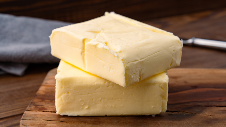 Two slabs of butter, unwrapped.