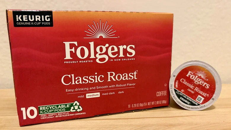 A box of Folgers Classic Roast K-cups and a single K-cup on a wooden table