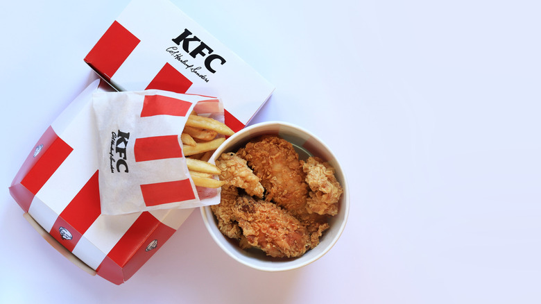 Bags of KFC takeout with a bucket of KFC fried chicken