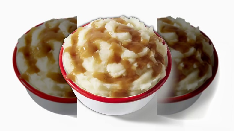 A red-rimmed bowl of KFC mashed potatoes and gravy