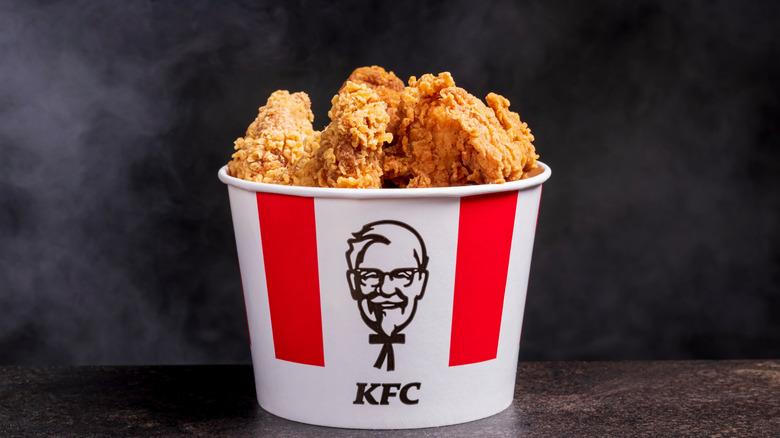 A classic bucket of crispy fried chicken inside a container with a KFC logo