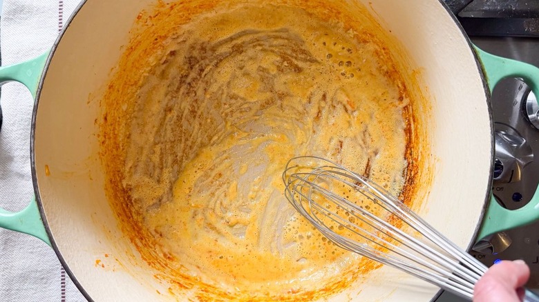 Whisking roux with kimchi in pot on stovetop