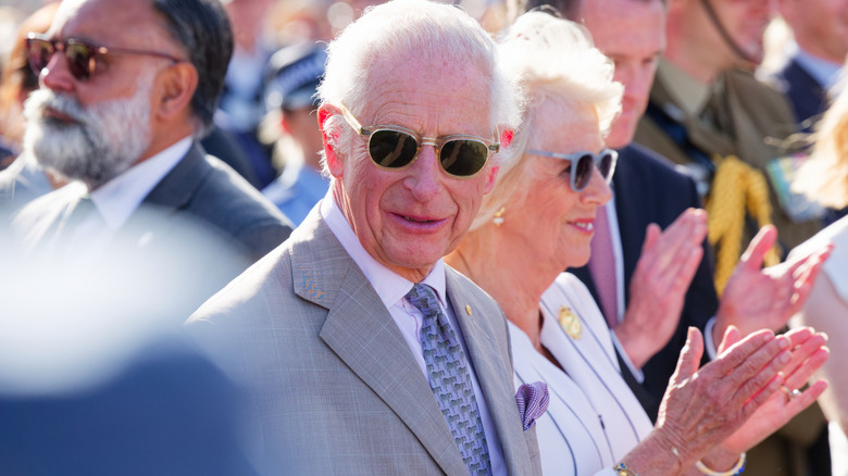 King Charles III wearing sunglasses in a crowd