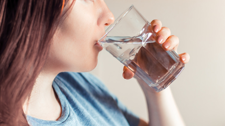 Person drinking a glass of water