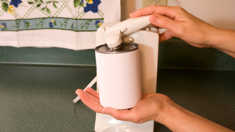 Person using an electric can opener