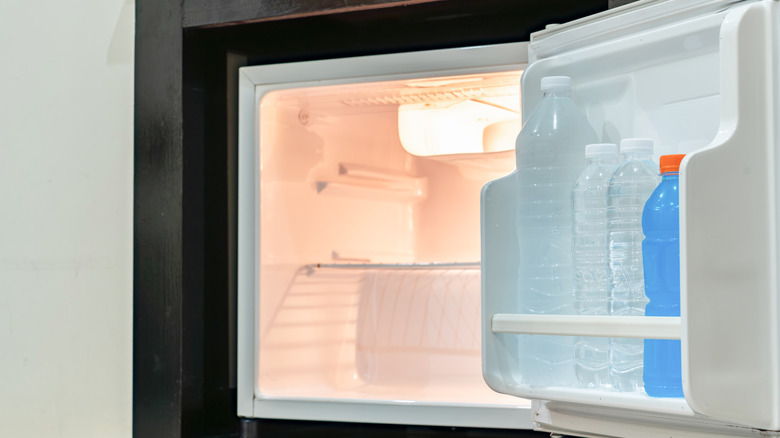 Mini fridge with bottles on the door