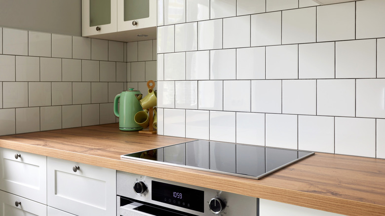 kitchen backsplash up underneath cabinet and hood