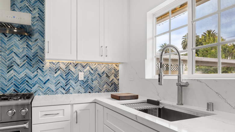 kitchen with basketweave mixed blue tiles and marble slabs