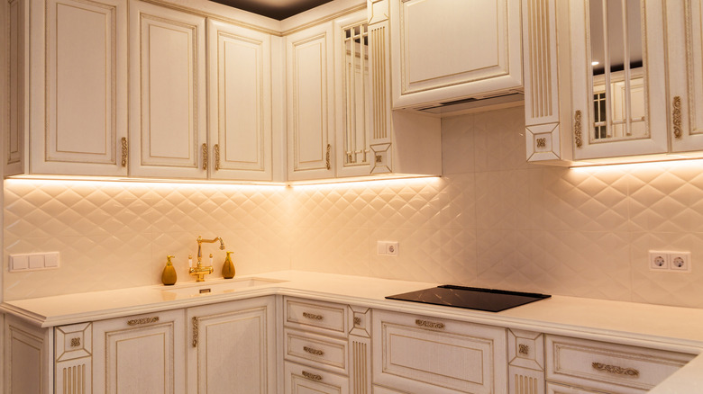 under cabinet lighting shining on white backsplash