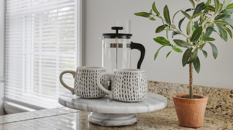 French press and coffee cups on serene counter