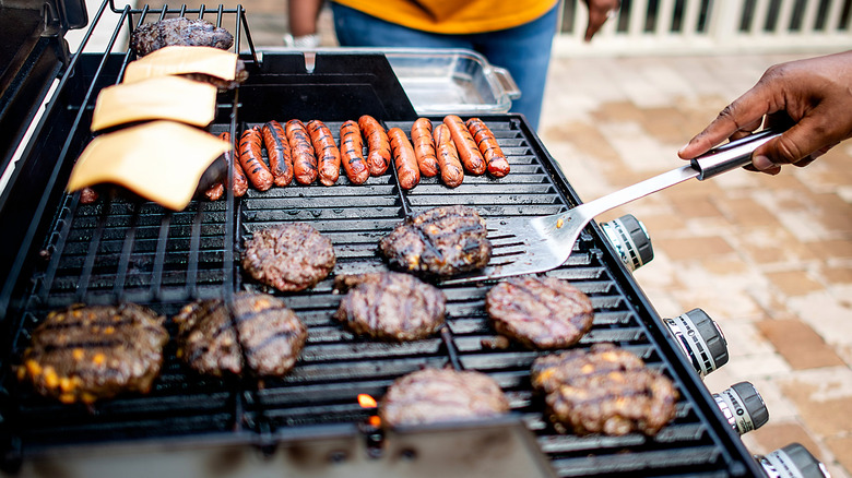Grill filled with hamburgers and hot dogs