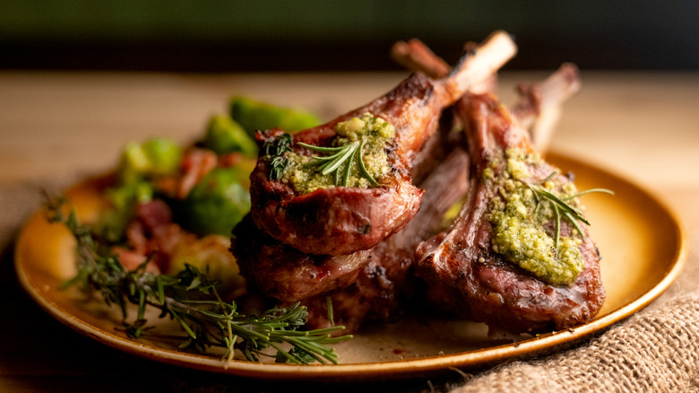 Charcoal grilled rack of lamb chops topped with pesto and rosemary