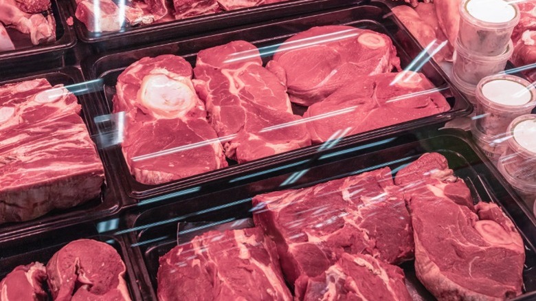 Various cuts of beef arranged in trays for sale.