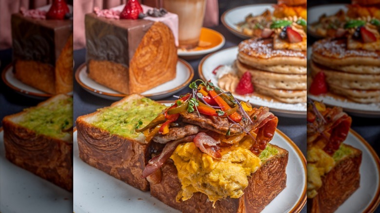 Bacon, egg, cheese, and avocado savory Cube croissant with pancakes and a sweet cube croissant in the background
