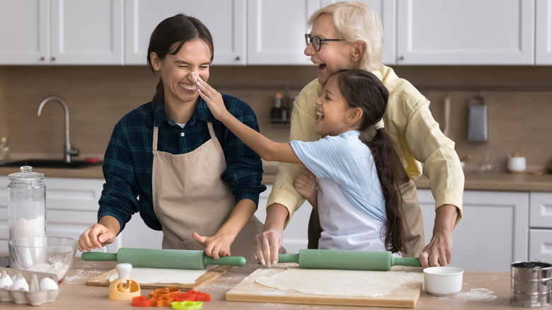 Three generations of females in the kitchen having fun creating and baking something.