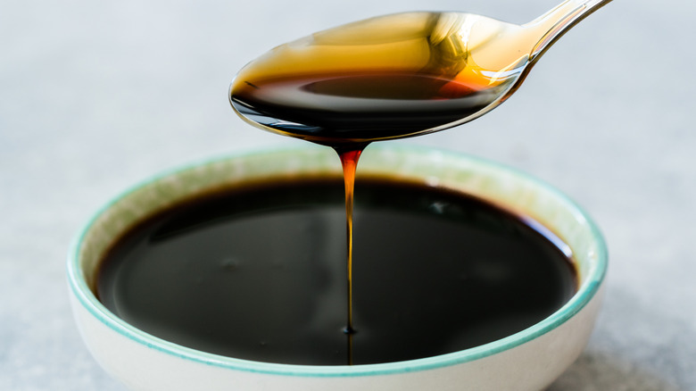 Molasses dripping from a spoon into a bowl