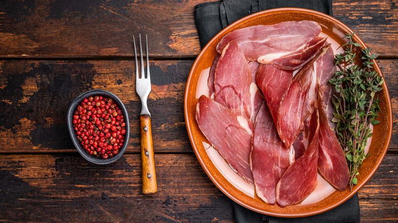 Italian speck in a plate on a table.
