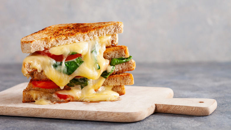 grilled cheese halved on a white cutting board