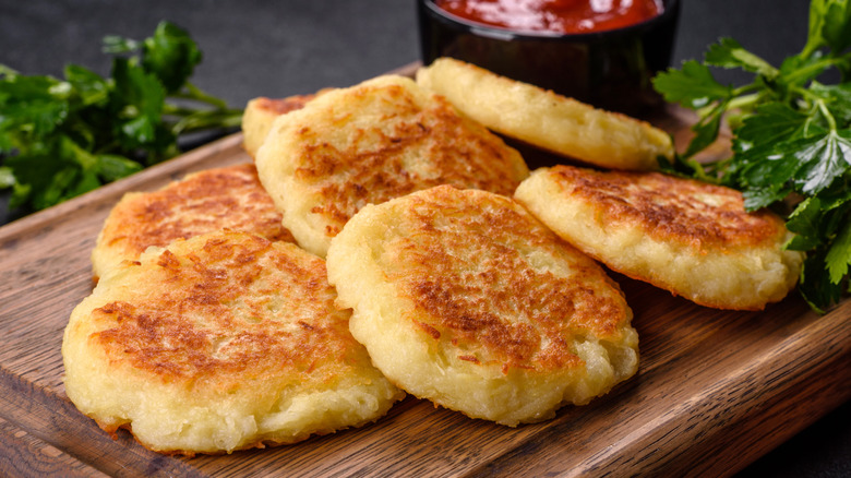 Fried potato patties on a wooden cutting board