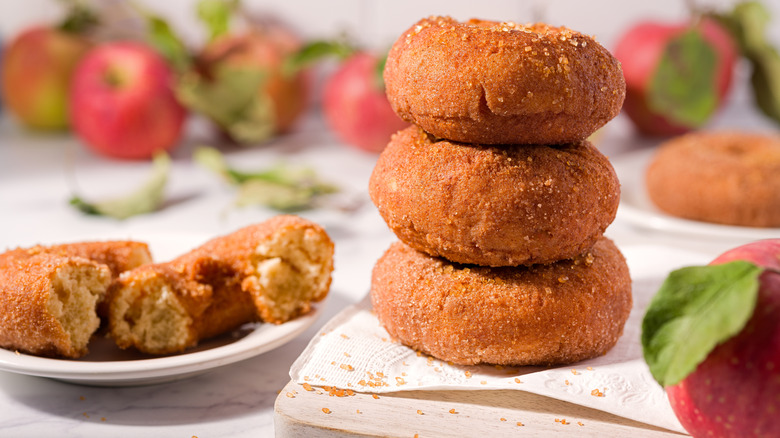Apple cider donuts stacked on a plate.