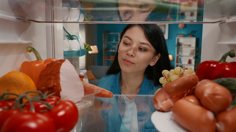 woman looking into fridge