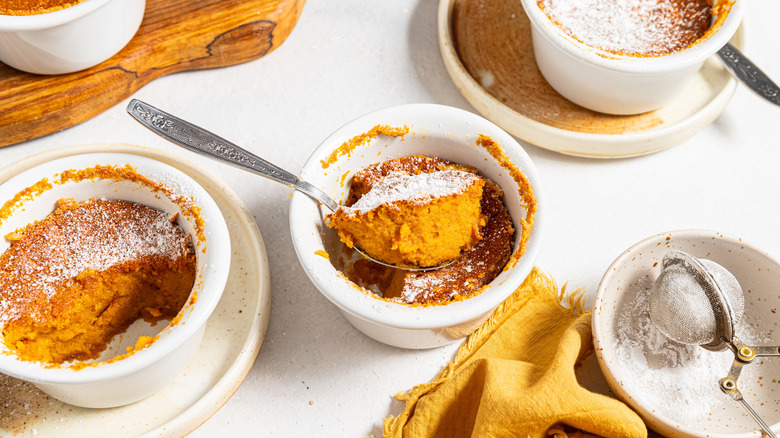 Carrot souffles in ramekins and a spoonful on top of one.