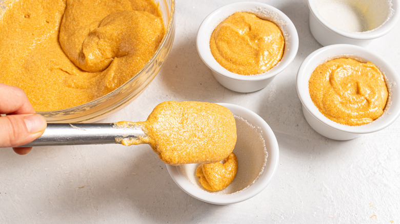 Filling ramekins with carrot souffle