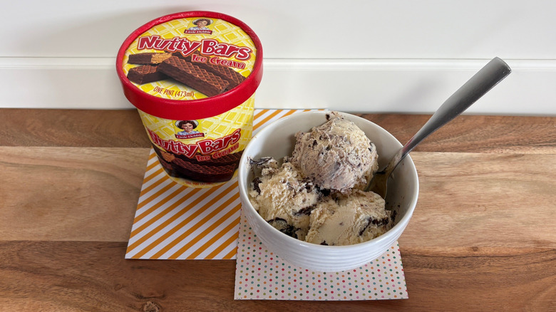 Little Debbie Nutty Bars ice cream next to a bowl of ice cream on colored napkins and cutting board