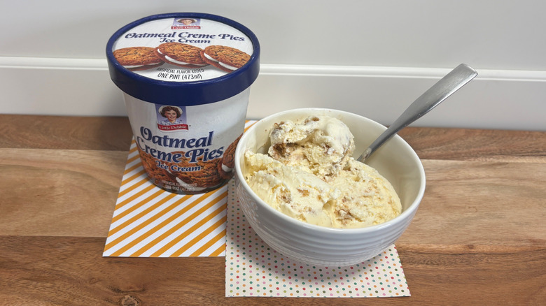 Little Debbie Oatmeal Creme Pies ice cream next to a bowl of ice cream on colored napkins and cutting board