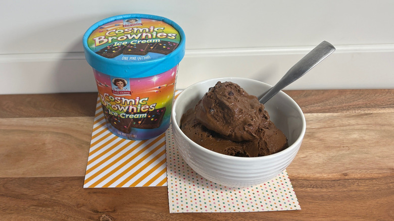 Little Debbie Cosmic Brownies pint next to a bowl of ice cream on colorful napkins and cutting board