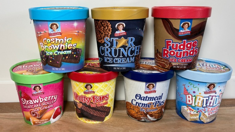 7 Little Debbie Ice Cream pints stacked on a wooden cutting board against a white background