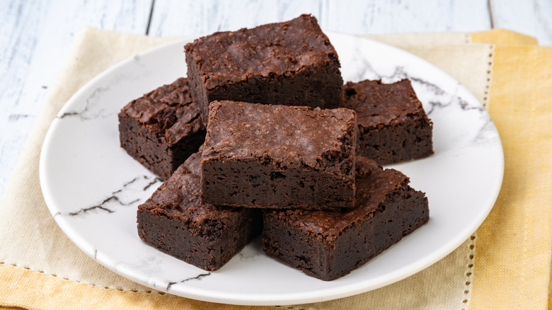 brownies on a plate over a white wooden table