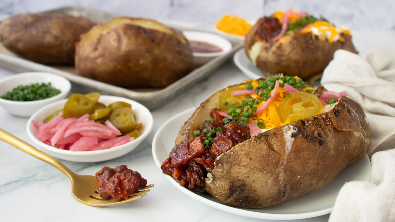 Loaded barbecue pork belly baked potatoes side shot close up