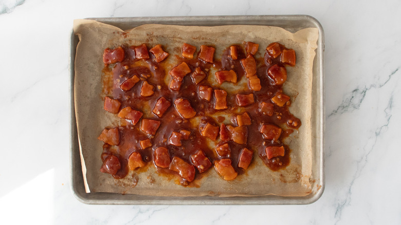 Barbecue sauced pork belly on a baking sheet