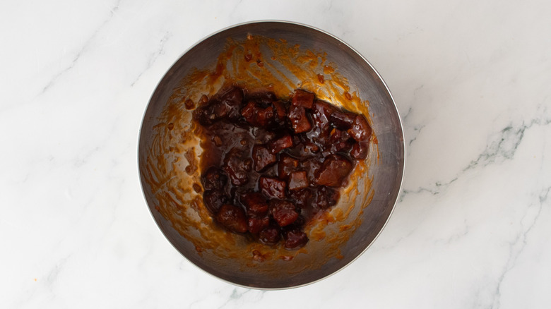 Crispy pork belly in a bowl coated in barbecue sauce