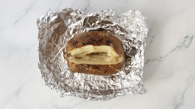 Baked potato, uncovered from the foil, and cut to expose the center