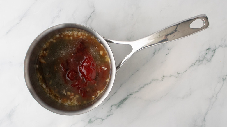 Small saucepan with barbecue sauce ingredients un-whisked