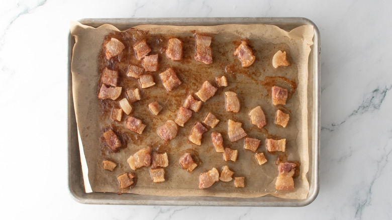 Par-baked pork belly pieces on a baking sheet