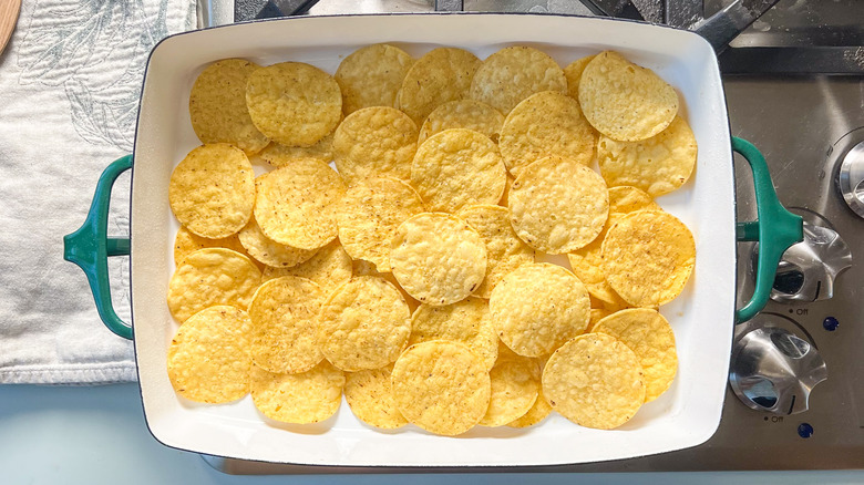 Round tortilla chips layered in baking pan