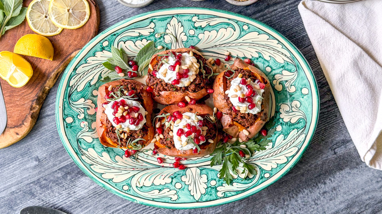 Loaded sweet potatoes with ras el hanout beef and lemon yogurt on serving platter