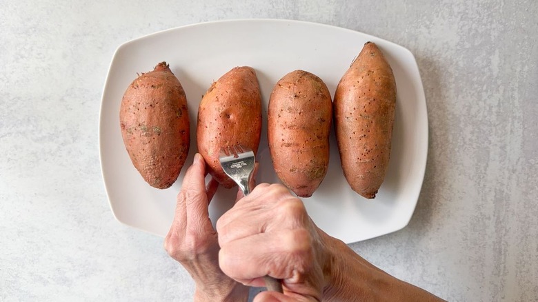 Pricking sweet potatoes with a fork