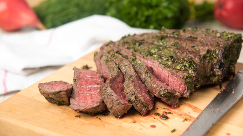 A sliced London broil steak on a cutting board