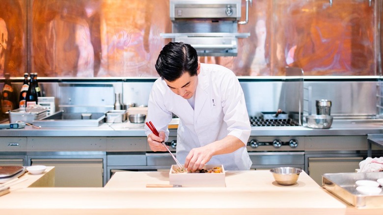 Hayato chef preparing a sushi dish behind a counter.