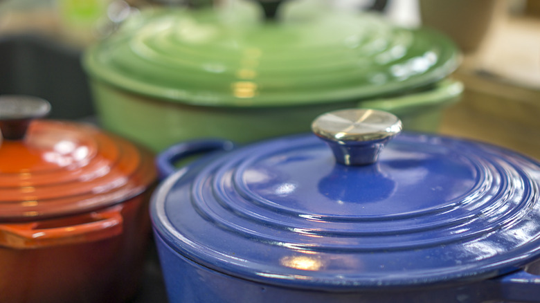 Enameled cast iron pots sit on a shelf