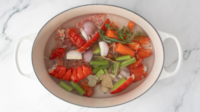 vegetables and lobster shells in a pot of water