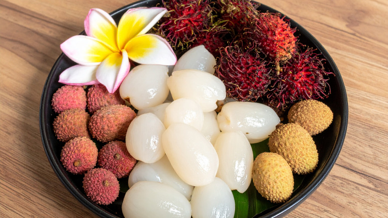 A platter with peeled lychees and rambutan