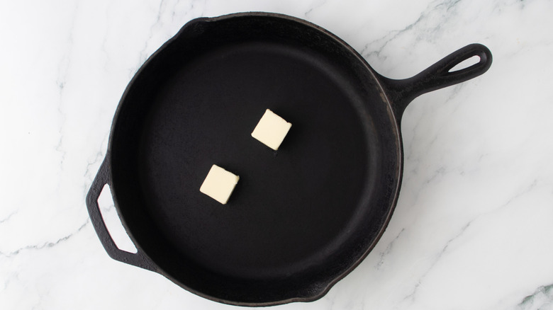 two slabs of butter in a pan on marble surface