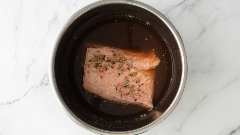 aerial view of corned beef with broth in slow cooker pot