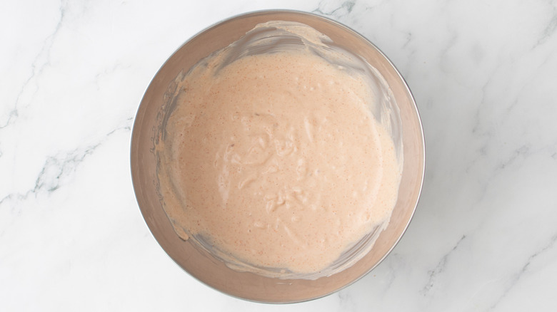 aerial view of whisked dressing in bowl on marble sruface