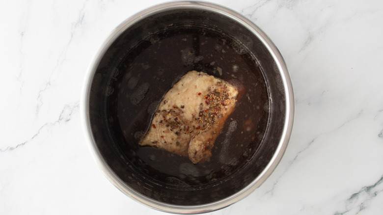aerial view of cooked corned beef resting in slow cooker
